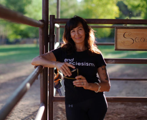 Photo of Joanne Cacciatore leaning on a farm gate